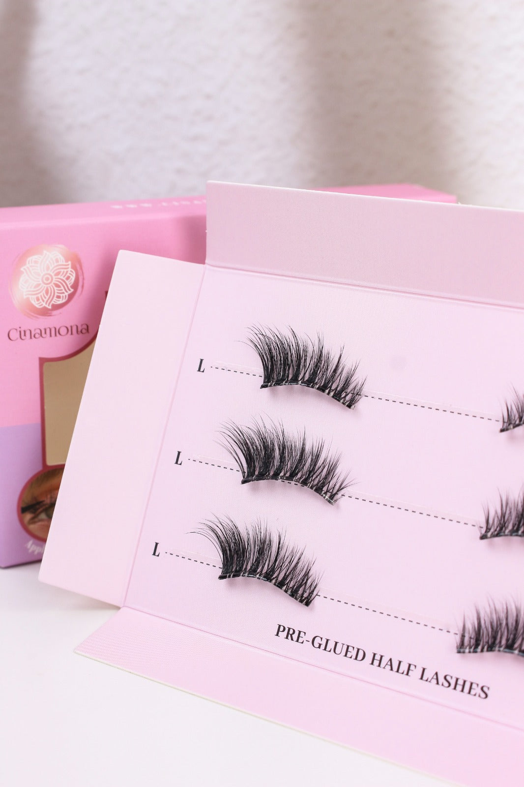 Set of false eyelashes in pink packaging on a light background