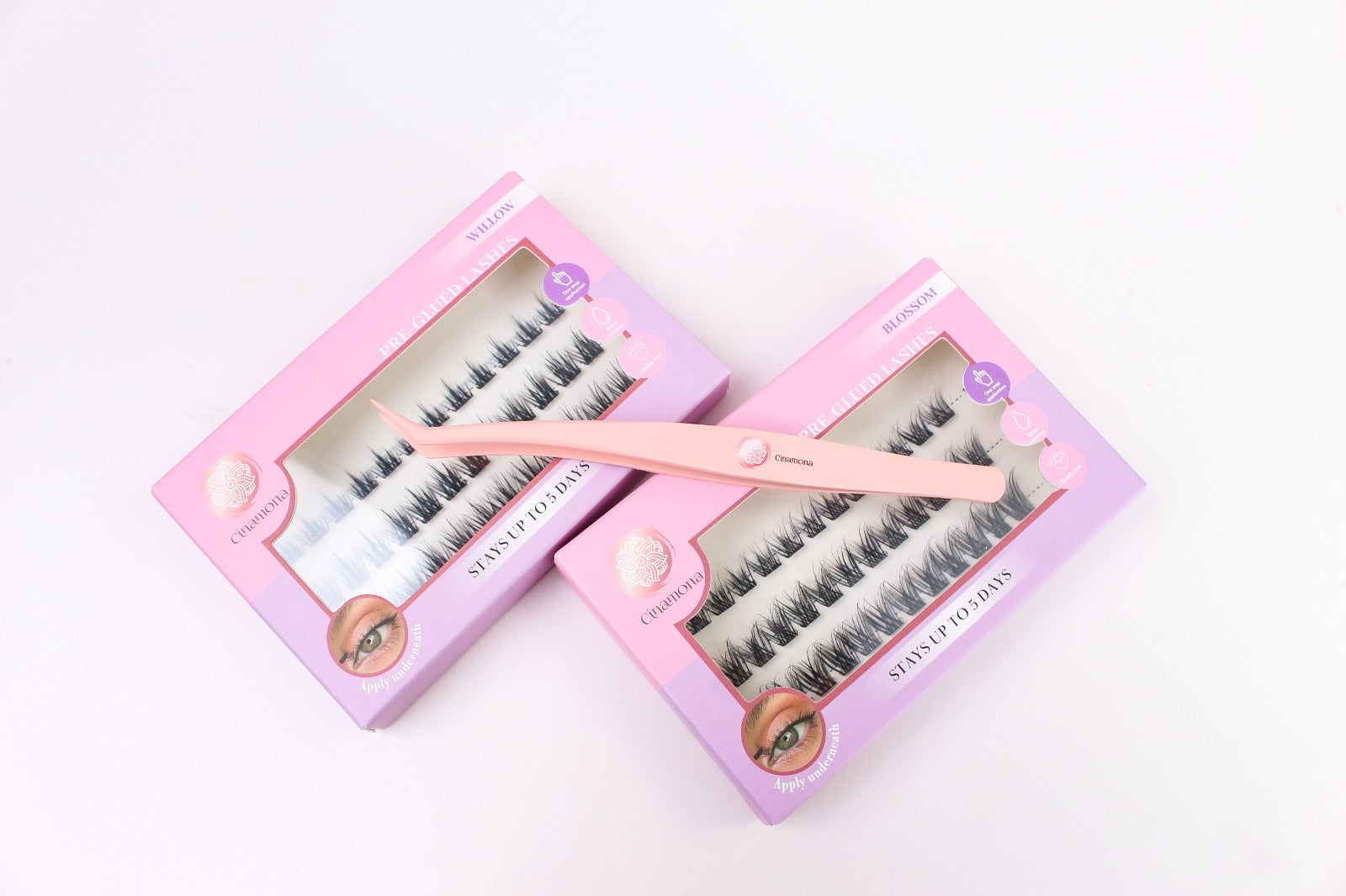False eyelashes in pink packaging with a applicator on a white background