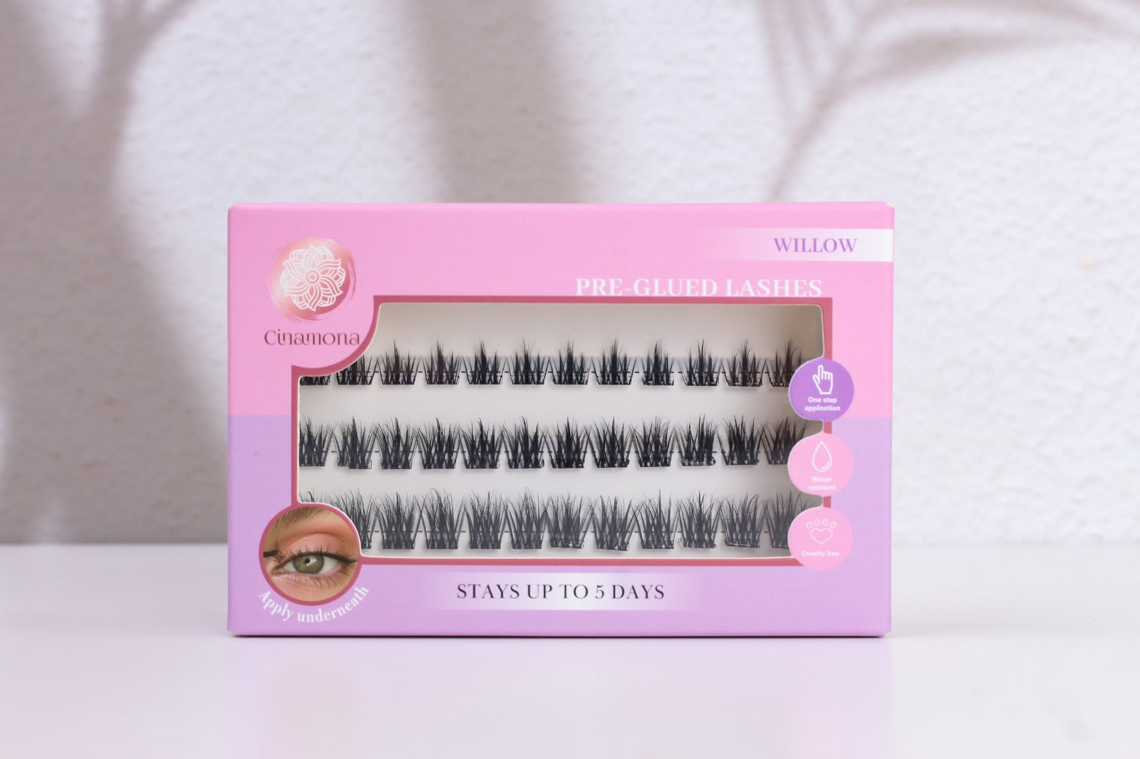 Pink and purple box of false eyelashes on a white background